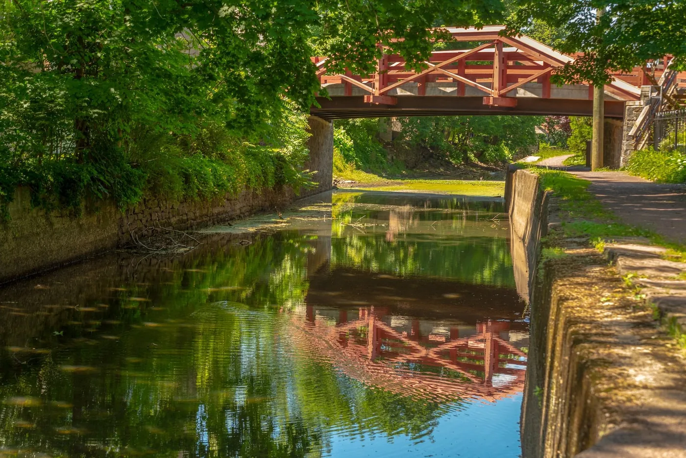 The Delaware Canal in New Hope, PA, with the red truss footbridge crossing it and the old mule towpath running alongside