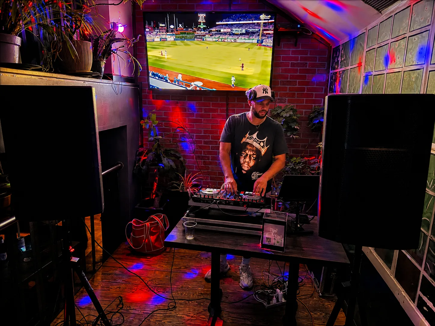 DJ playing at GreenHouse in New Hope, PA, with coloured lighting and the brick wall behind