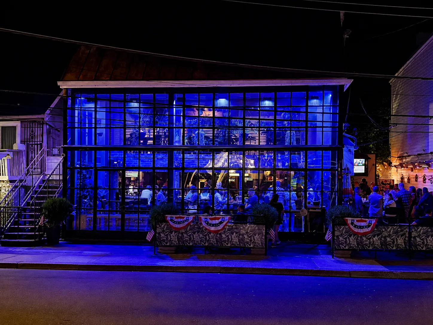The glass front of GreenHouse on South Main Street, New Hope, PA, lit blue at night