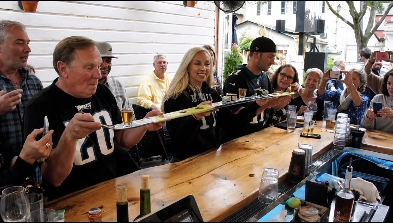 Guests taking a shot ski at the GreenHouse outdoor bar on an Eagles game day in New Hope, PA